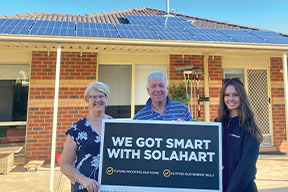 Happy Solahart customers holding a "we got smart with Solahart" sign
